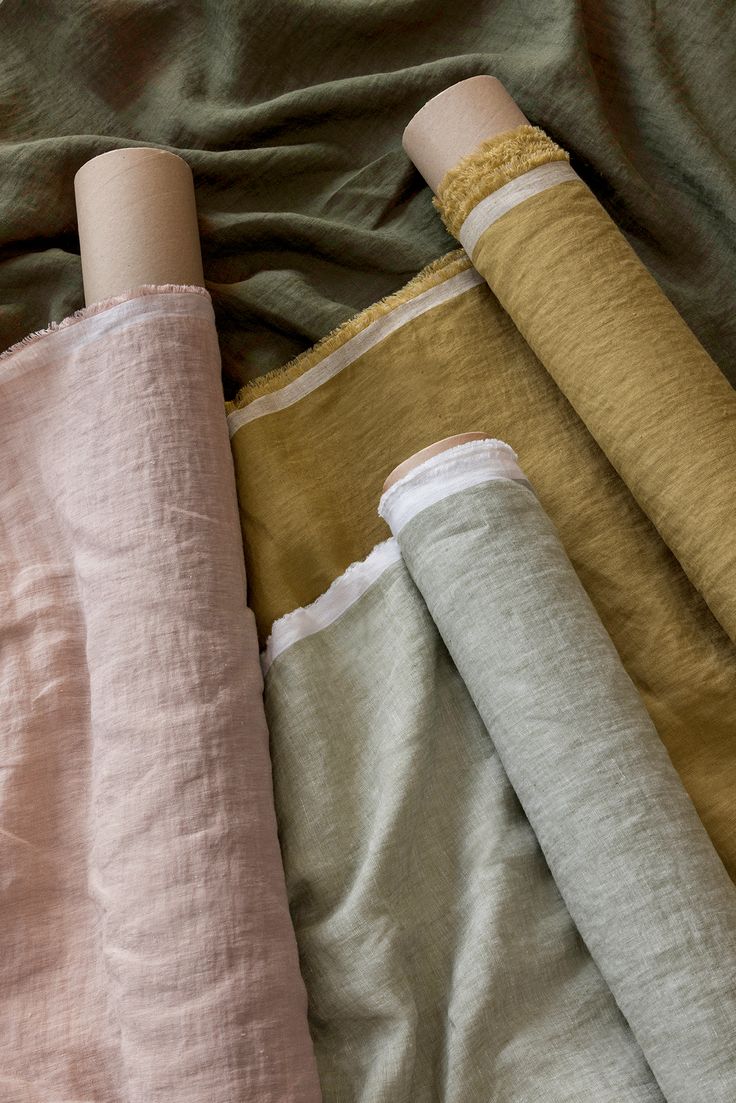 rolled up linens are laying on top of each other in different colors and sizes