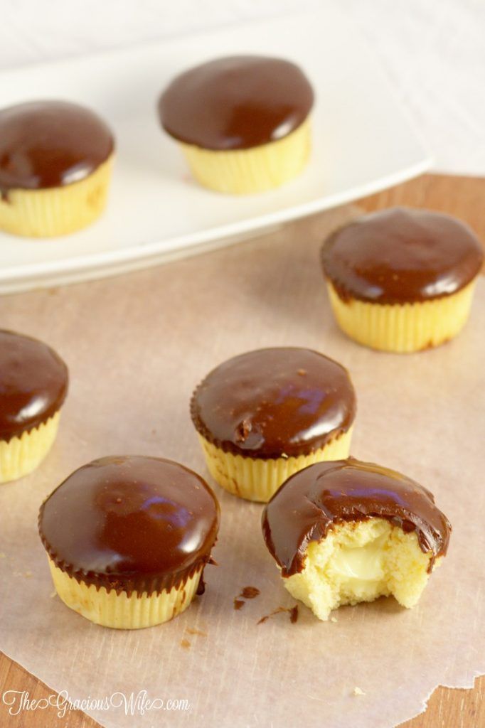 chocolate covered cupcakes sitting on top of a paper towel next to a white plate