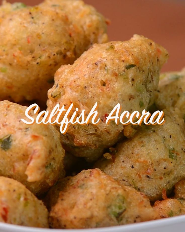 a white bowl filled with fried food on top of a wooden table and the words safffish accra above it