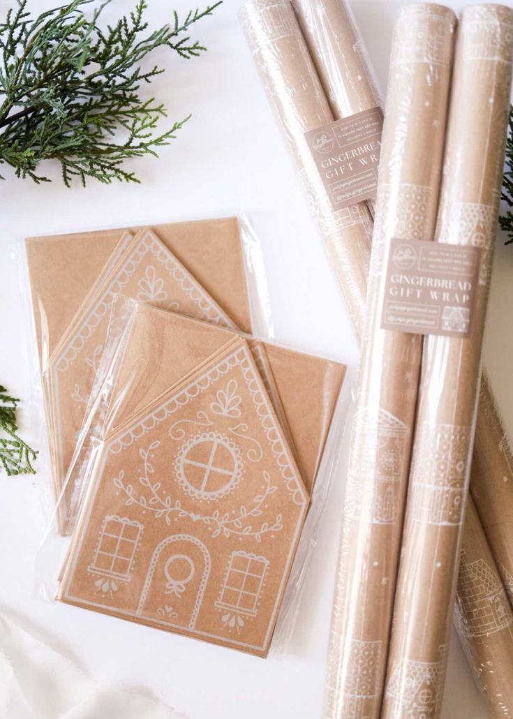 some brown wrapping paper sitting on top of a white table next to christmas decorations and greenery