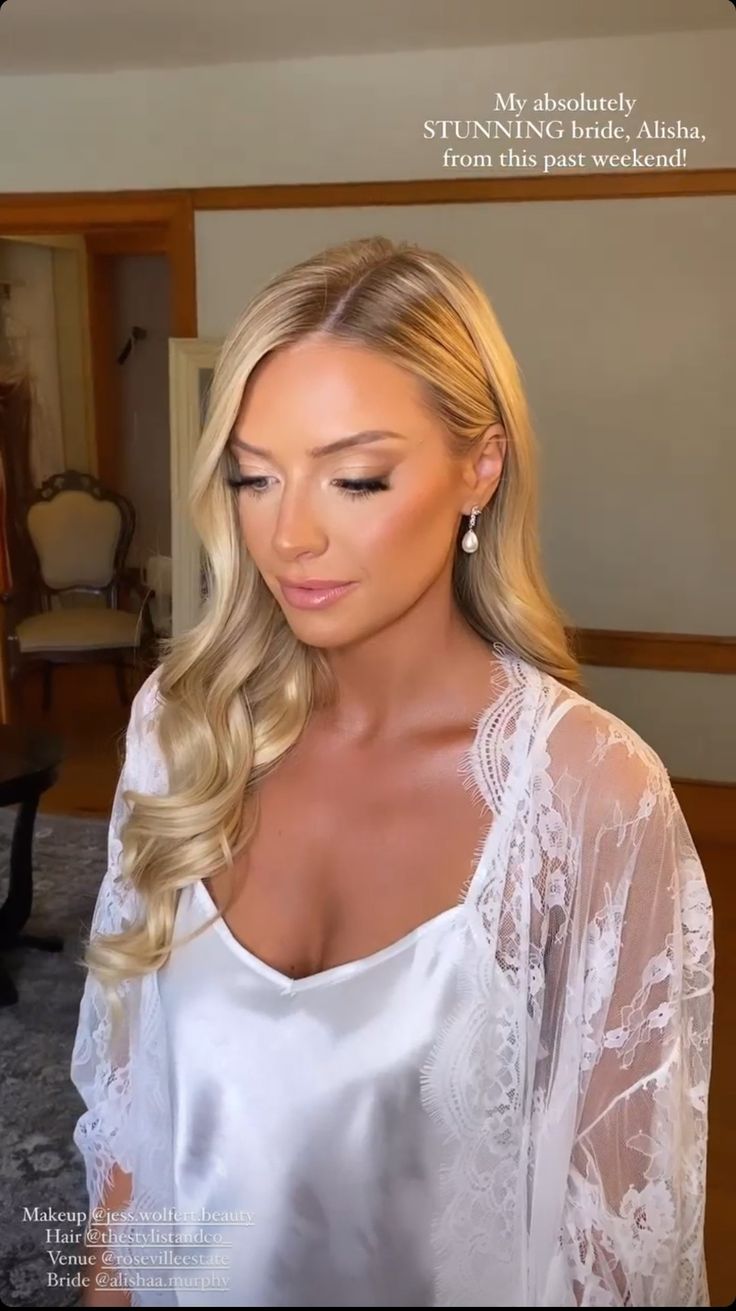 a beautiful blonde woman with long hair wearing a white top and posing for the camera