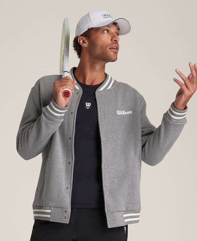 Suit up in timeless sport style. An easy layer to snap over a polo or tee, the Hudson Bomber Jacket brings a touch of luxury to the court. It's made of premium tricot fabric that feels comfortably breathable and wonderfully soft against your skin. Wilson branding accents this bomber, nodding to a hundred-year legacy on the court. | Wilson Hudson Bomber Jacket Varsity Jacket With Logo Detail, Sporty Spring Sweatshirt With Logo Detail, Sporty Spring Sweatshirt With Logo, Casual Outerwear With Logo And Baseball Collar, Sporty Winter Outerwear With Logo Detail, Cotton Outerwear With Logo And Crew Neck, Casual Varsity Jacket With Logo And Baseball Collar, Sporty Long Sleeve Varsity Jacket With Logo, Classic Fall Outerwear With Logo