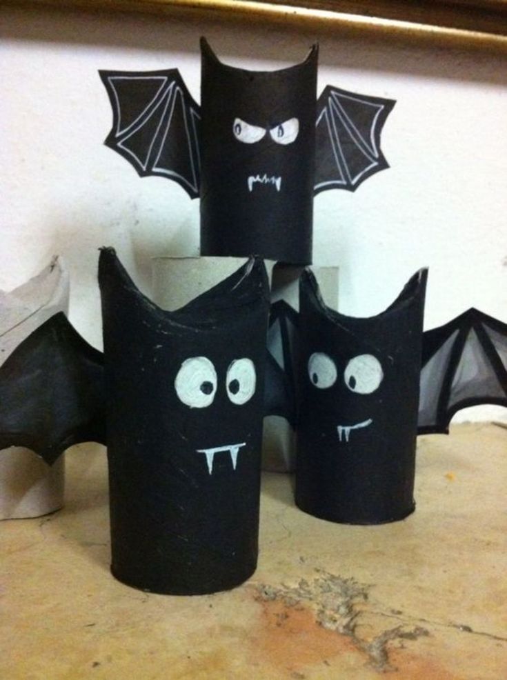 four black paper cups with bats and eyes on the top one is shaped like a bat