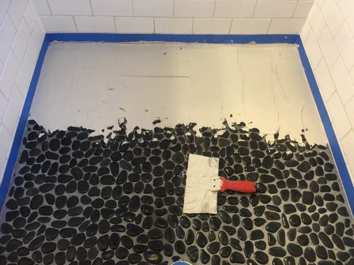 a bathroom with black and white tiles on the floor, blue trim around the edge