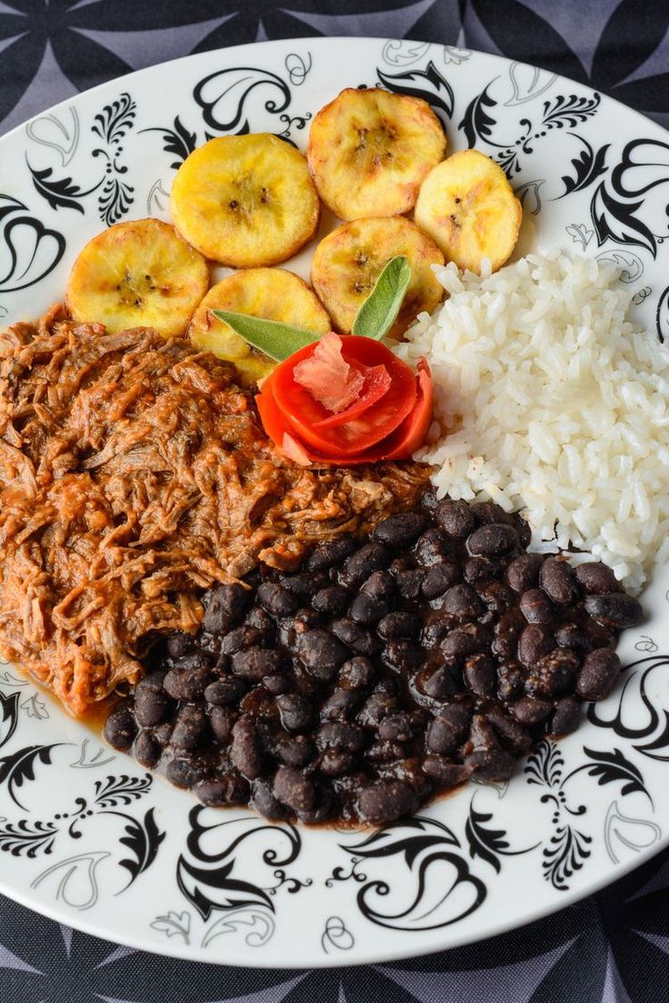 a white plate topped with rice and beans next to sliced banana's on top of it