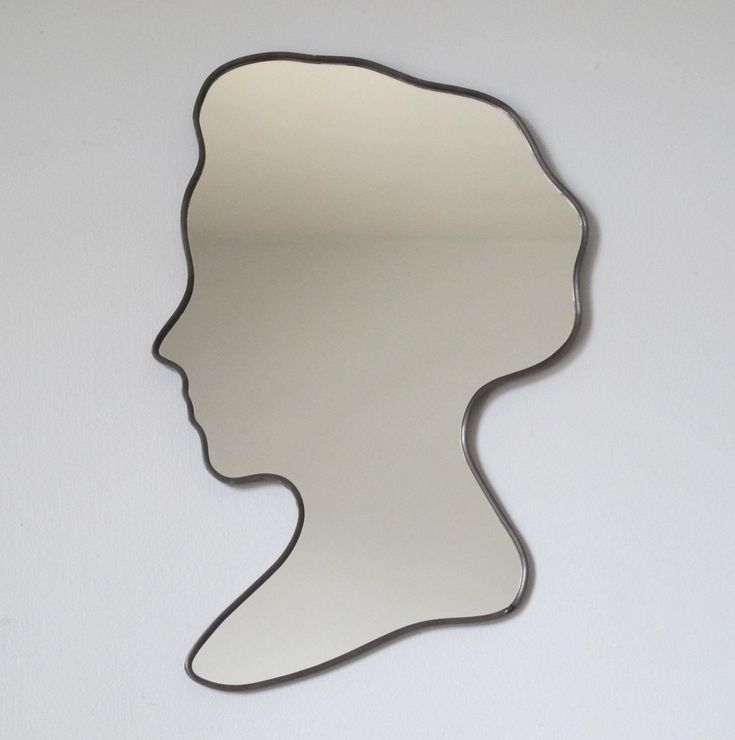 a person's head is shown in the shape of a mirror, against a white wall