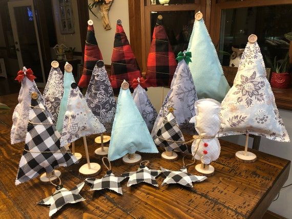 a group of christmas trees sitting on top of a wooden table