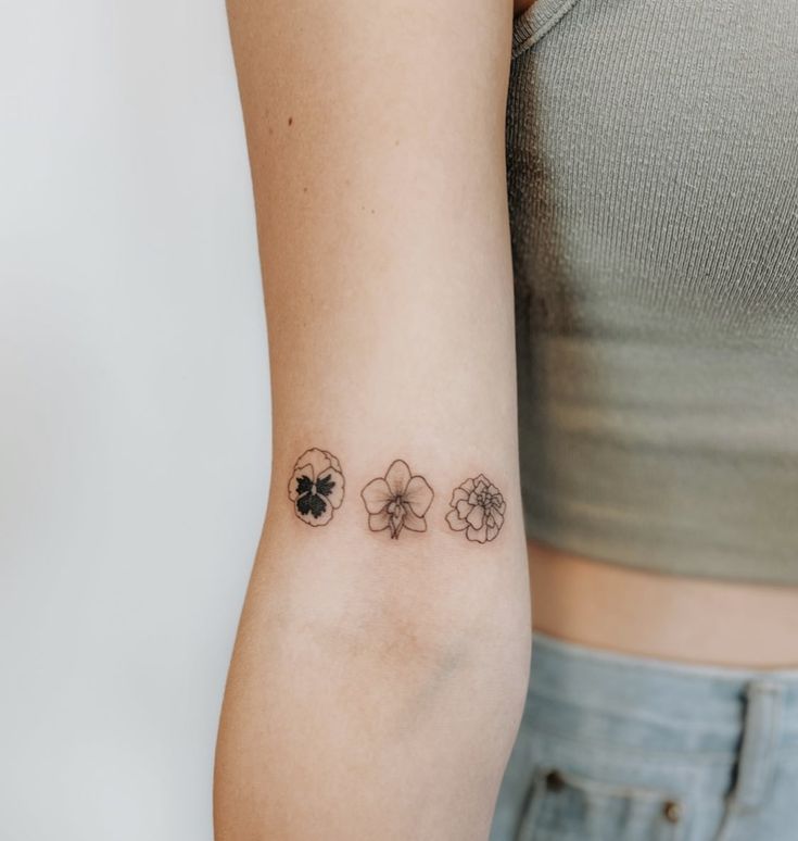 a woman's arm with four clover tattoos on it