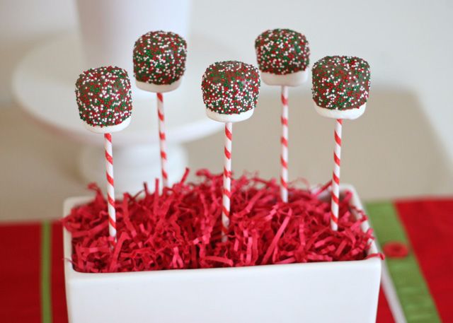 cake pops with sprinkles in a white box on red carpeted table