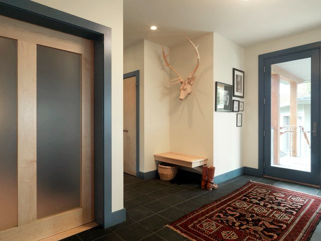 an entry way with deer heads mounted on the wall and rug in front of it