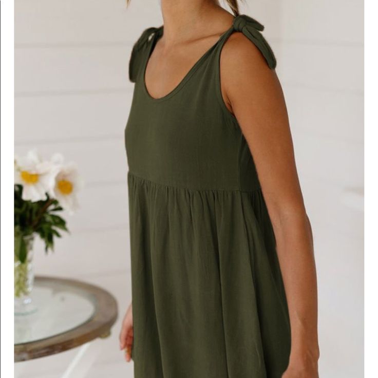 Mini Sun Dress In Army Green With Ties At The Shoulder Spring Casual Mini Dress With Tie Straps, Casual Spring Mini Dress With Tie Straps, Casual Mini Dress With Tie Straps For Spring, Casual Solid Sundress With Tie Straps, Casual Summer Dress With Bow, Summer Mini Dress With Tie Fastening For Daywear, Summer V-neck Mini Dress With Bow, Casual Sleeveless Mini Dress With Bow, Green Casual Mini Dress With Tie Straps