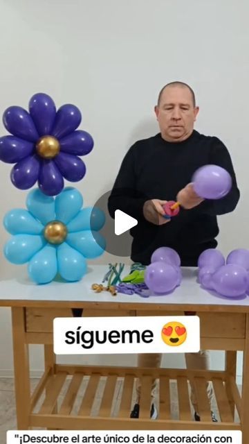 a man standing in front of a table with balloons