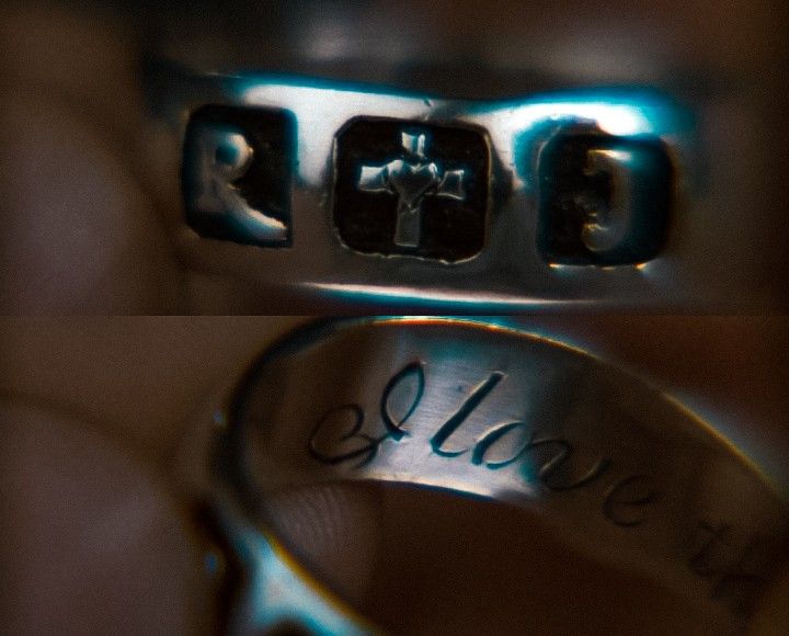 two wedding rings with the word love engraved on each side and an image of a cross in the middle