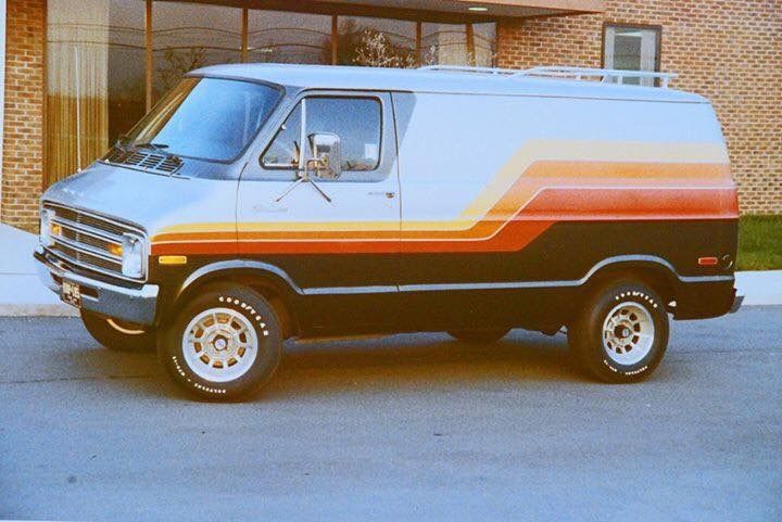 a van parked in front of a building on the side of the road with an orange and white stripe painted on it