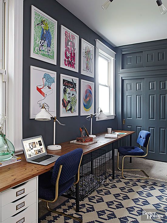 an image of a home office with blue walls and pictures on the wall above it