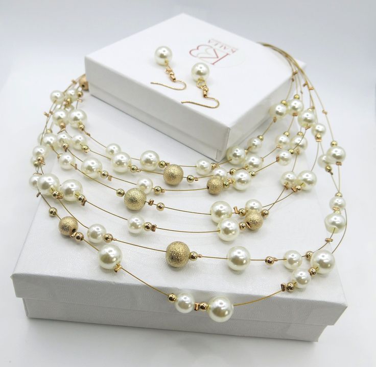 Bridal bead and pearl multi strand floating necklace and earring set in gold tone finish. Minimalist wedding jewelry pearl necklace and earrings 3 PC jewelry set.A simple yet classy style of multi-strand beaded pearl necklace and a pair of matching earrings will add an instant elegance to a wedding look or any special occasion. The multiple sized metal beads and pearl are spread casually over thin gold tone wire to create one-of-a-kind floating beads effect. The set makes a wonderful addition to Wedding Jewelry Pearls Necklace, Minimalist Wedding Jewelry, Jewelry Pearl Necklace, Beaded Pearl Necklace, Bridal Statement Necklace, Pearl Necklace And Earrings, Pearl Bridesmaid Jewelry, Beach Jewelry Boho, Bridal Jewelry Necklace