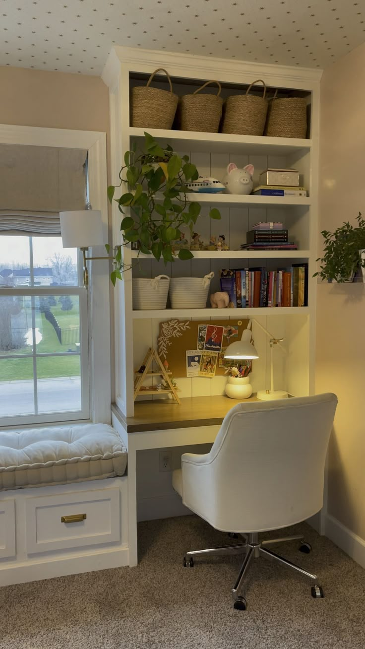 a white chair sitting in front of a desk with a book shelf on top of it