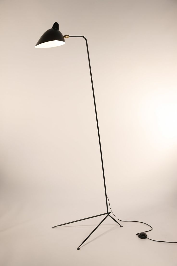 a black floor lamp with a white light on the side and a gray wall behind it