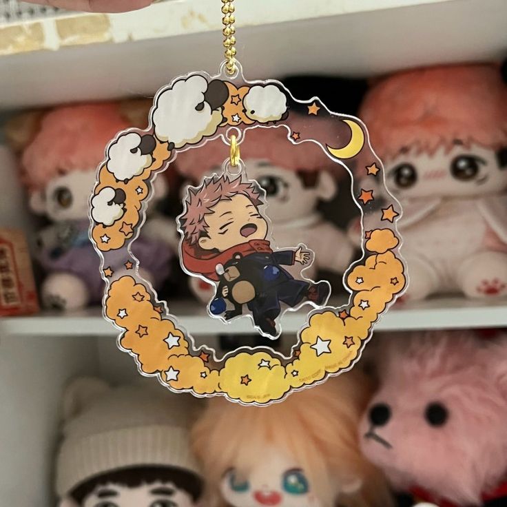 an anime keychain hanging from a shelf filled with stuffed animals and other toys