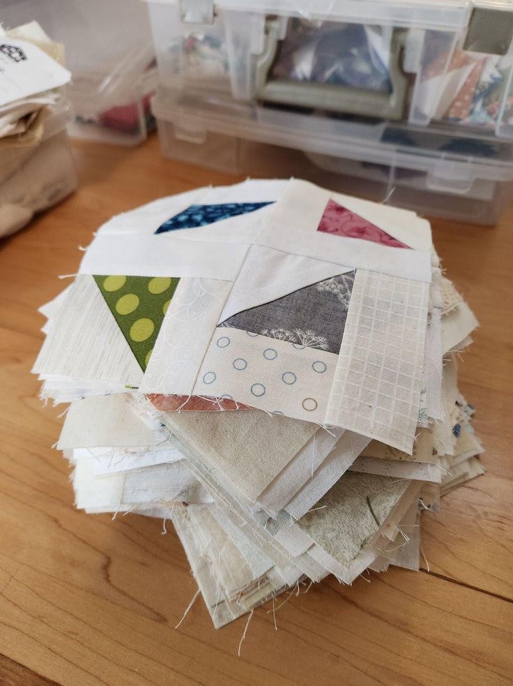 a pile of scrap paper sitting on top of a wooden table