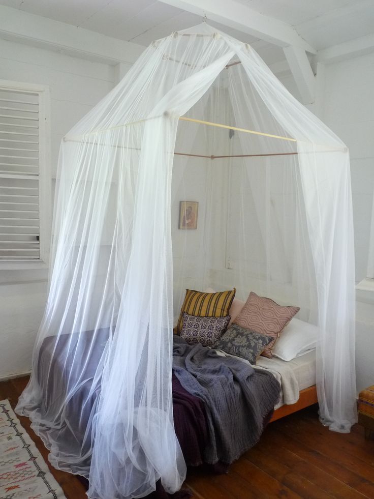 a bed with white mosquito netting over it