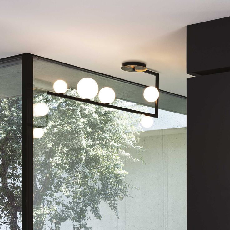 a bathroom with a sink, mirror and lights on the wall next to each other