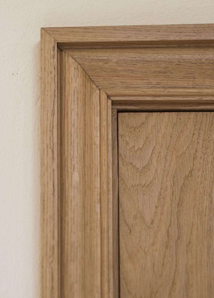 a close up of a wooden door frame on a white wall with wood graining