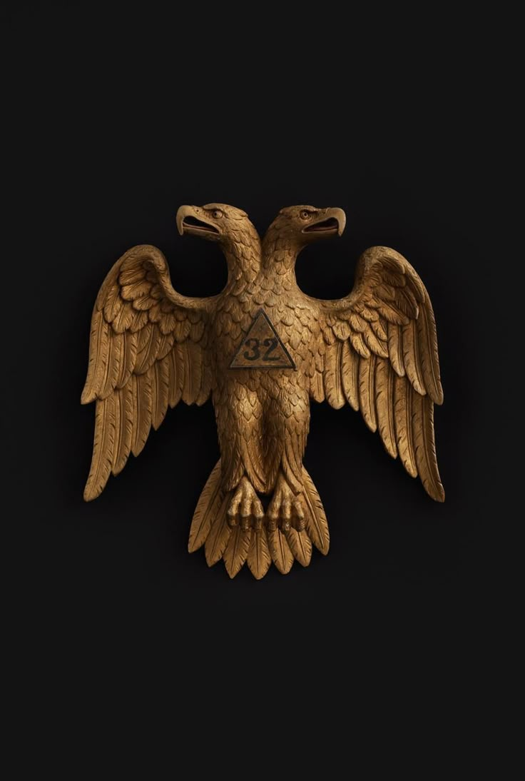 the golden eagle is on display against a black background with an embossed triangle