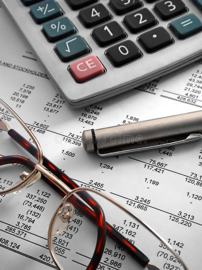 glasses, pen and calculator sitting on top of papers with numbers in the background