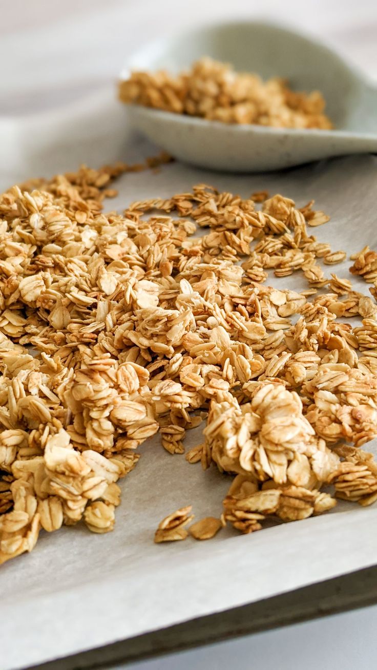 rolled oats on a baking sheet next to a spoon