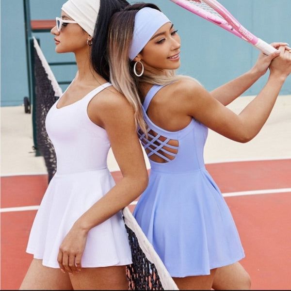 two beautiful young women holding tennis racquets on a tennis court