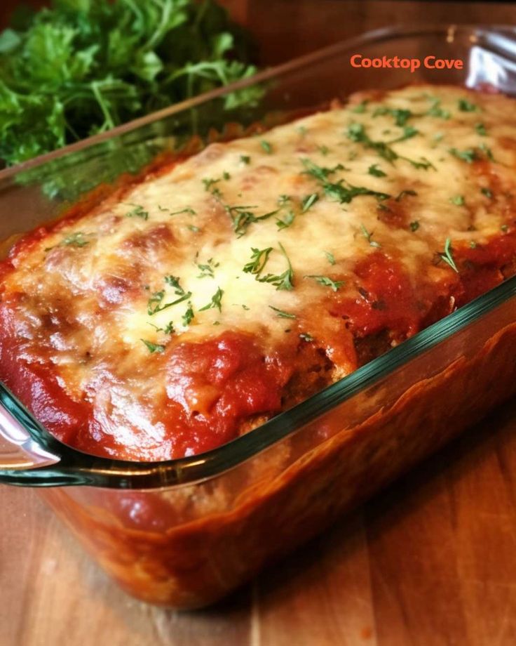 a casserole dish with meat and cheese in it sitting on a wooden table