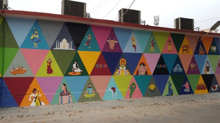 a colorful wall painted with many different colored shapes and people on it's sides