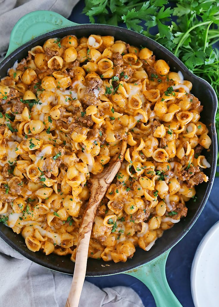 a skillet filled with macaroni and cheese on top of a blue cloth