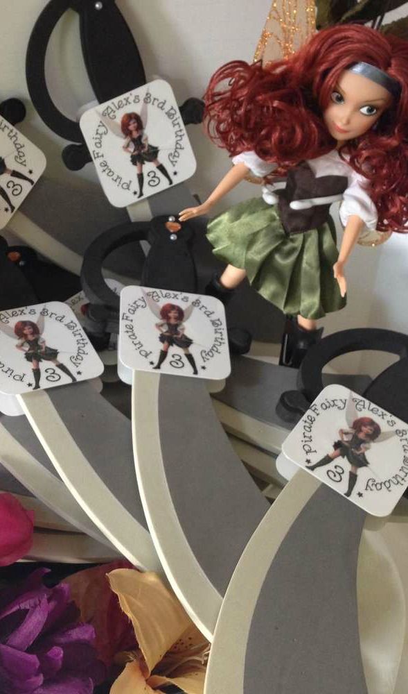 there is a doll with red hair on top of a shelf and some tags in front of it