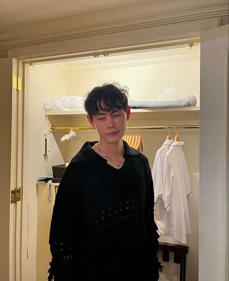 a young man standing in front of a closet