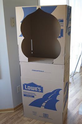 a cardboard box sitting on top of a hard wood floor next to a white wall