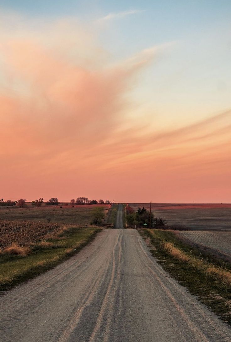 an empty dirt road in the middle of nowhere