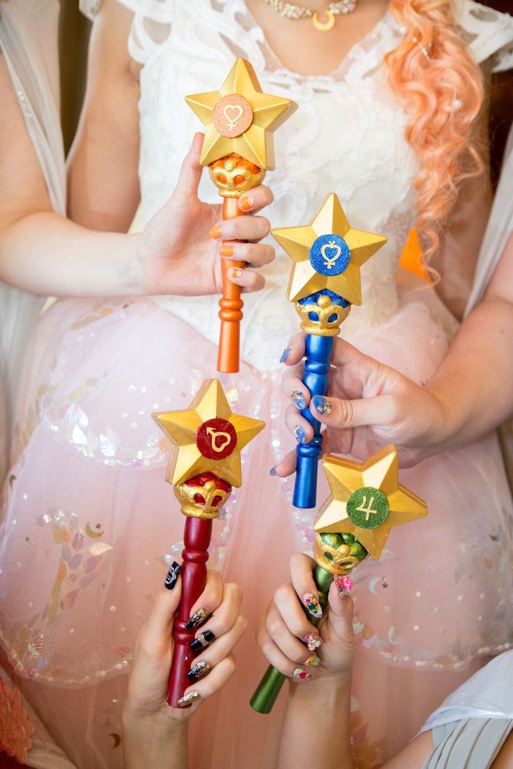 two girls are holding small star wands in their hands and one girl is wearing a pink dress