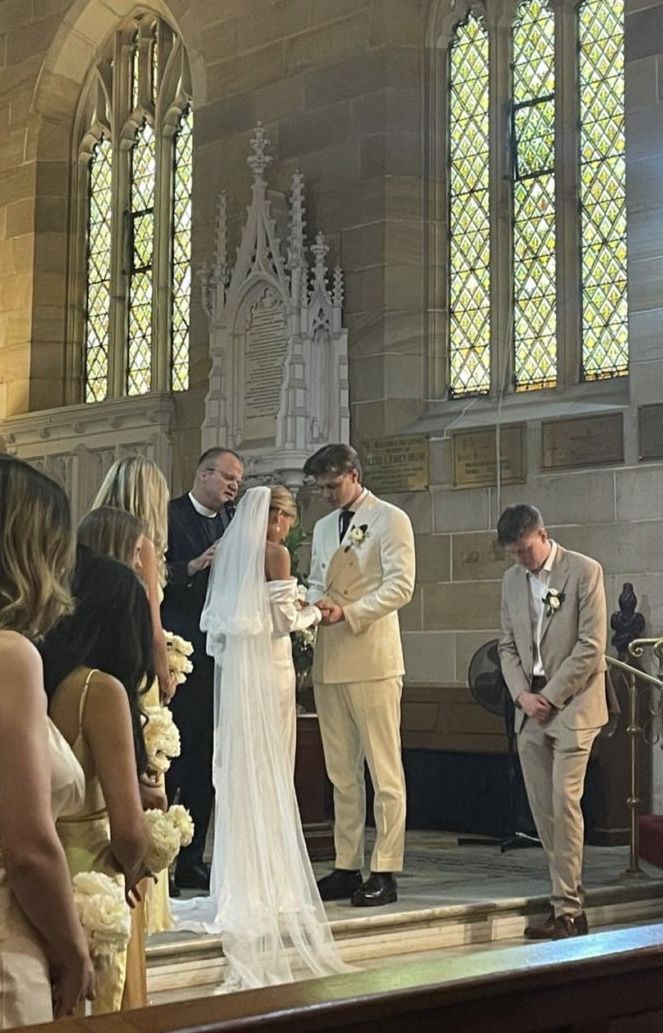 a bride and groom standing in front of the alter at their wedding ceremony with other people