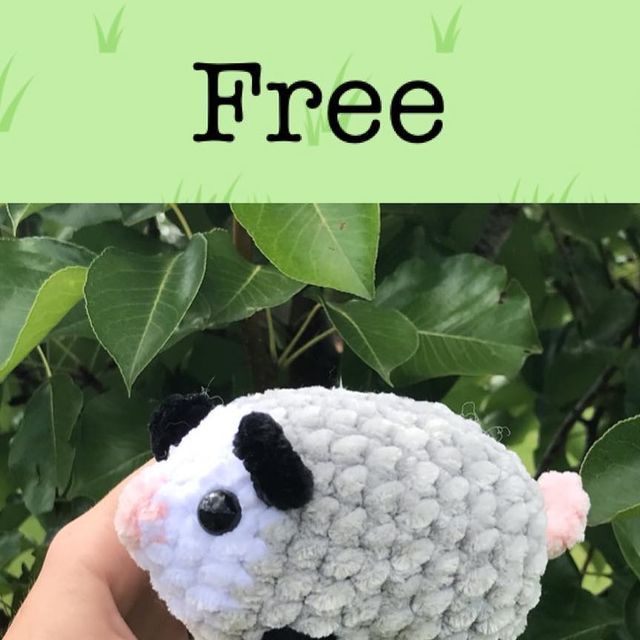 a hand holding a small stuffed sheep in front of some leaves with the words free on it