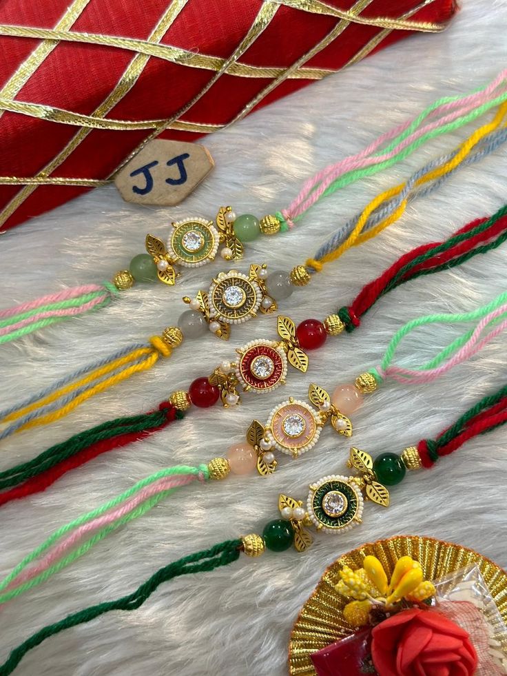 a bunch of colorful beads laying on top of a white fur covered floor next to a red bag