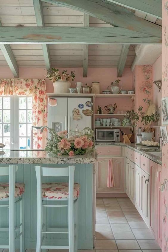 a kitchen with pink walls and floral curtains on the windowsills, two stools in front of an island