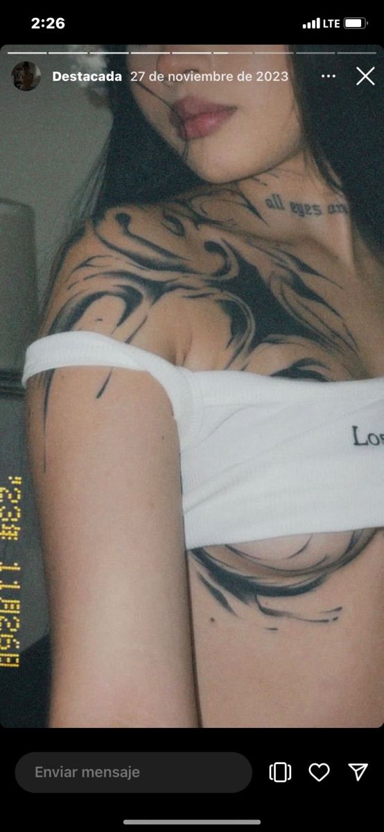 a woman with tattoos on her chest and arm