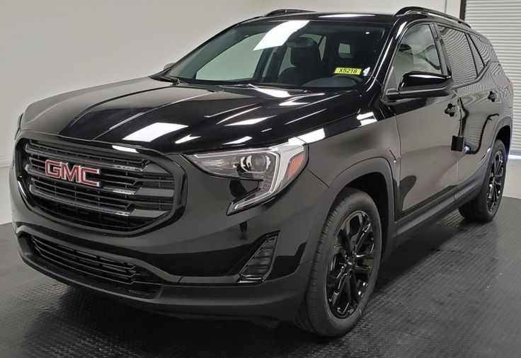 a black gmc suv is parked in a garage