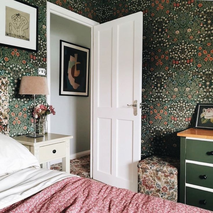 a bed room with a neatly made bed next to a dresser and a painting on the wall