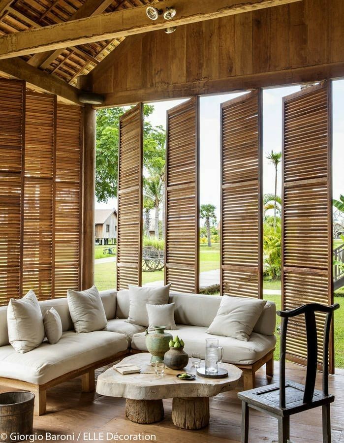 a living room filled with lots of furniture and wooden slats on the windowsill