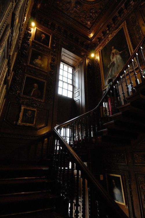 an ornate staircase with paintings on the walls