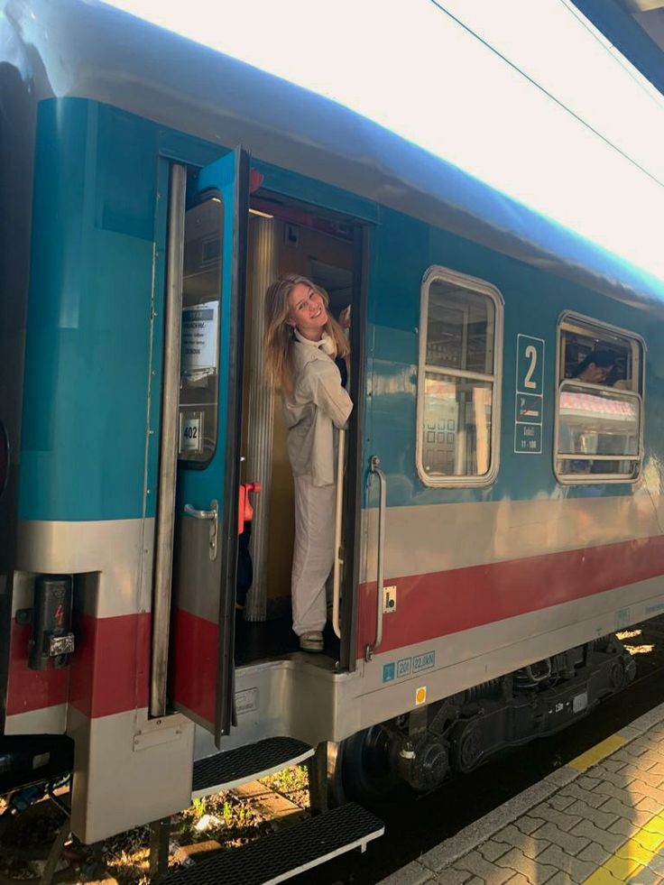 a woman standing in the open door of a train