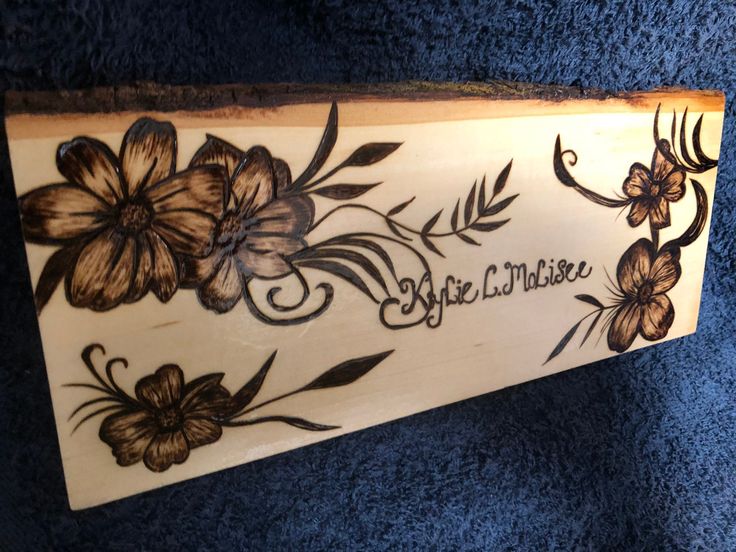 a wooden sign with flowers painted on it